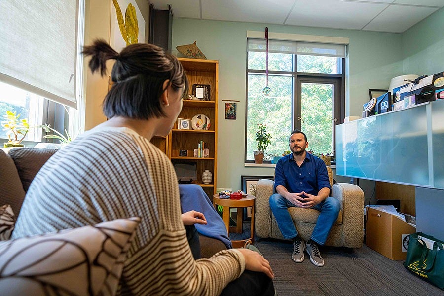 two people sitting and conversing in a room